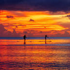 Enlarged detail of the Tumon Bay Sunset print, highlighting the sharp silhouettes of paddleboarders on the water.