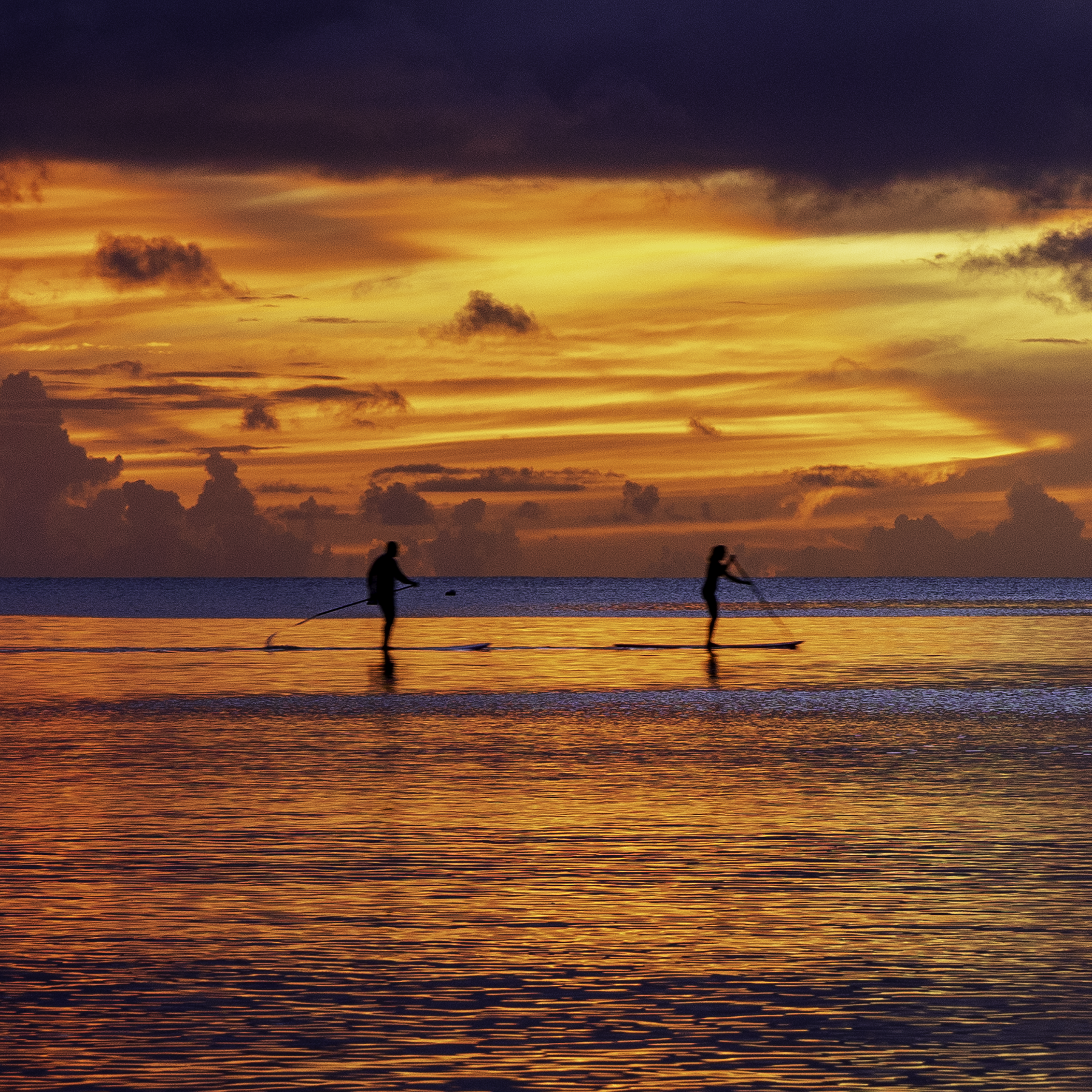 Enlarged detail of the Tumon Bay Sunset print, highlighting the sharp silhouettes of paddleboarders on the water.