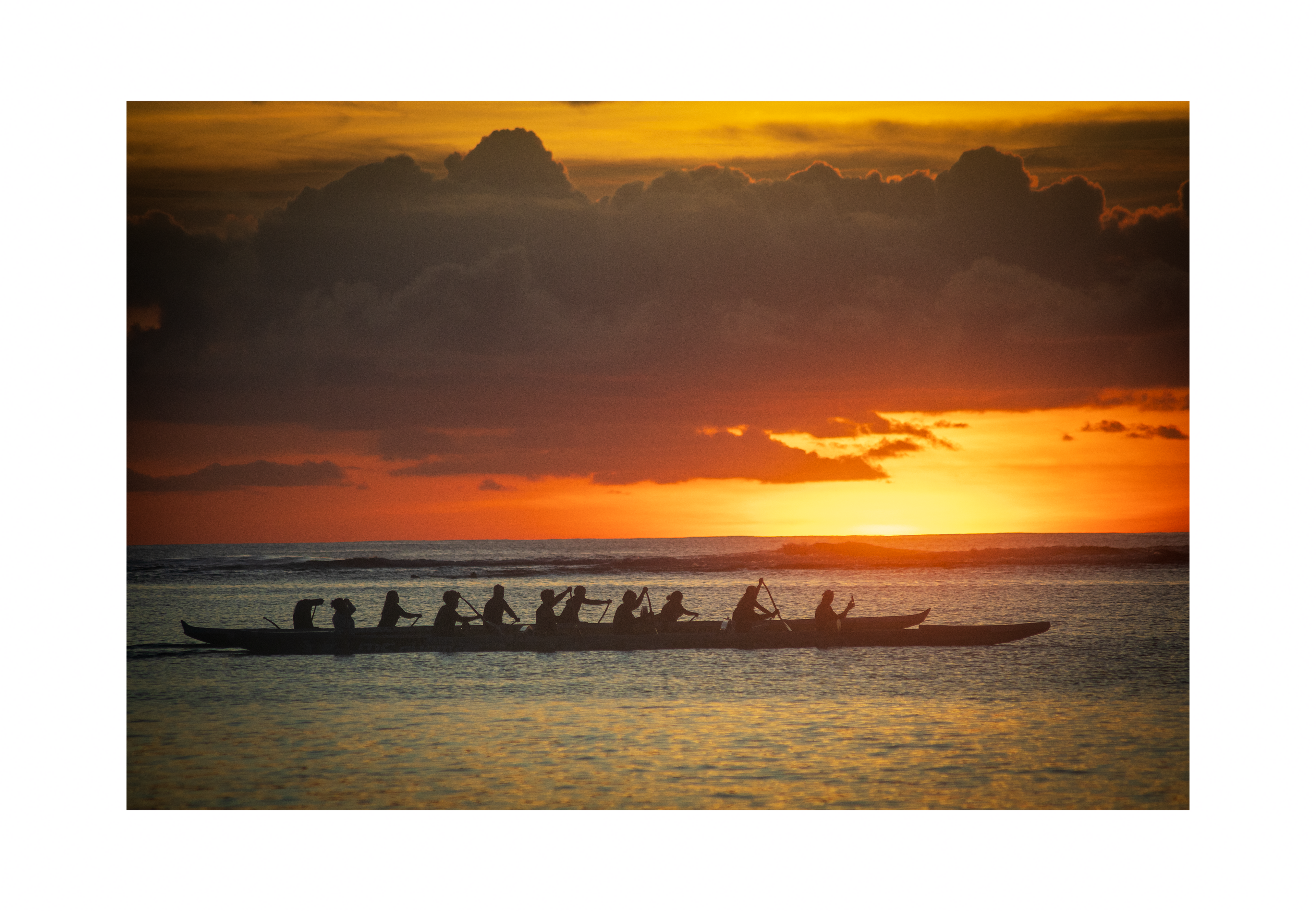 A 12x8 inch fine art print of an outrigger canoe at sunset, showing the product dimensions and clean white border margins.
