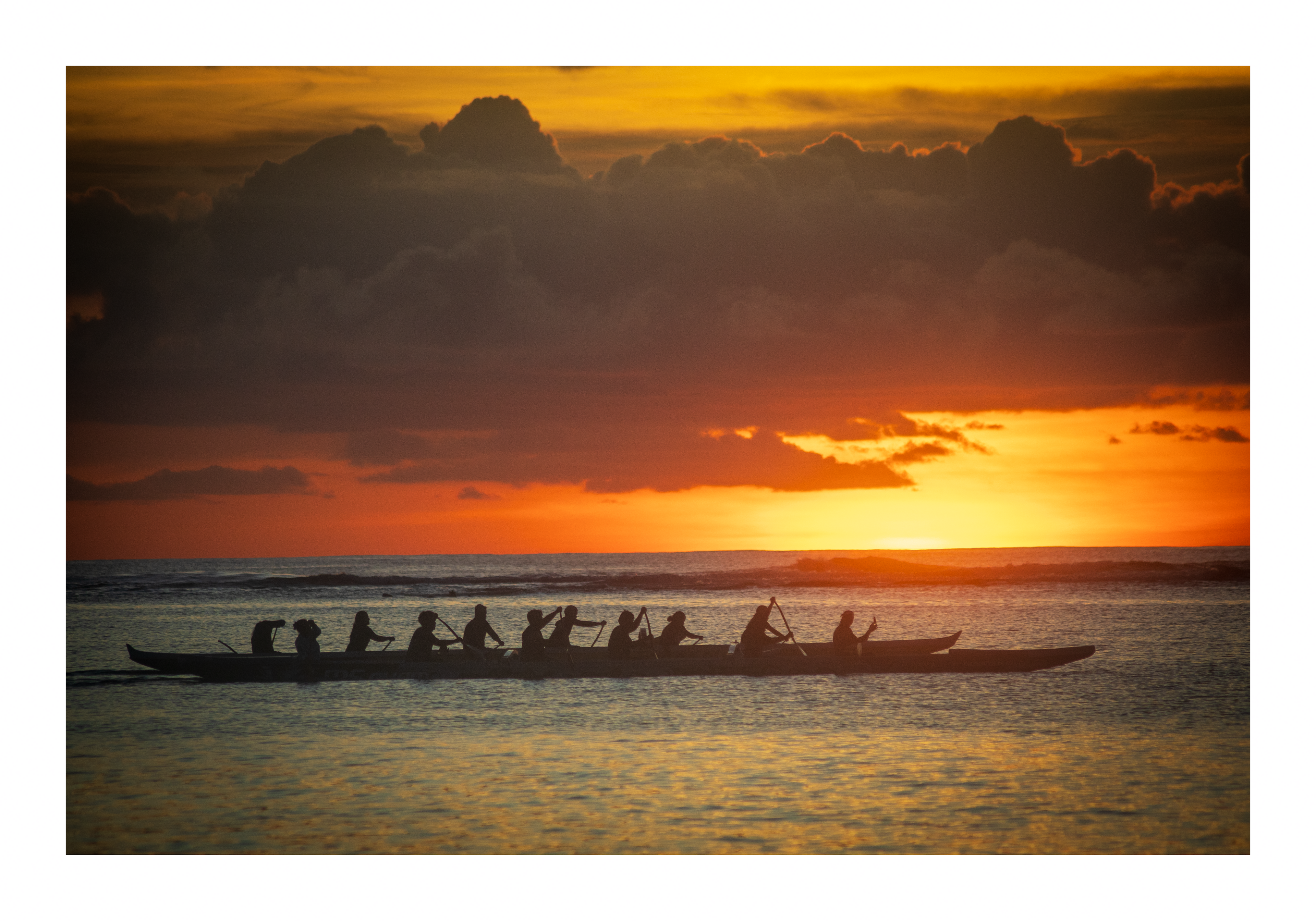 A 18x12 inch fine art print of an outrigger canoe at sunset, showing the product dimensions and clean white border margins.