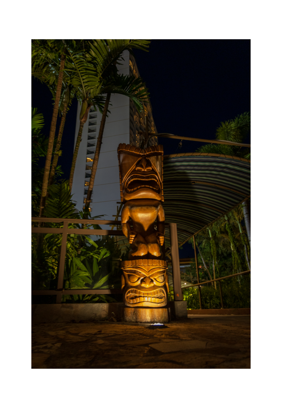 An 8x12 inch fine art travel print of an illuminated tiki totem in Guam, showing product dimensions and clean white border margins.