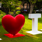 A close-up view focusing on the smooth, vibrant red heart sculpture of the I Love Tumon landmark sign in Guam.