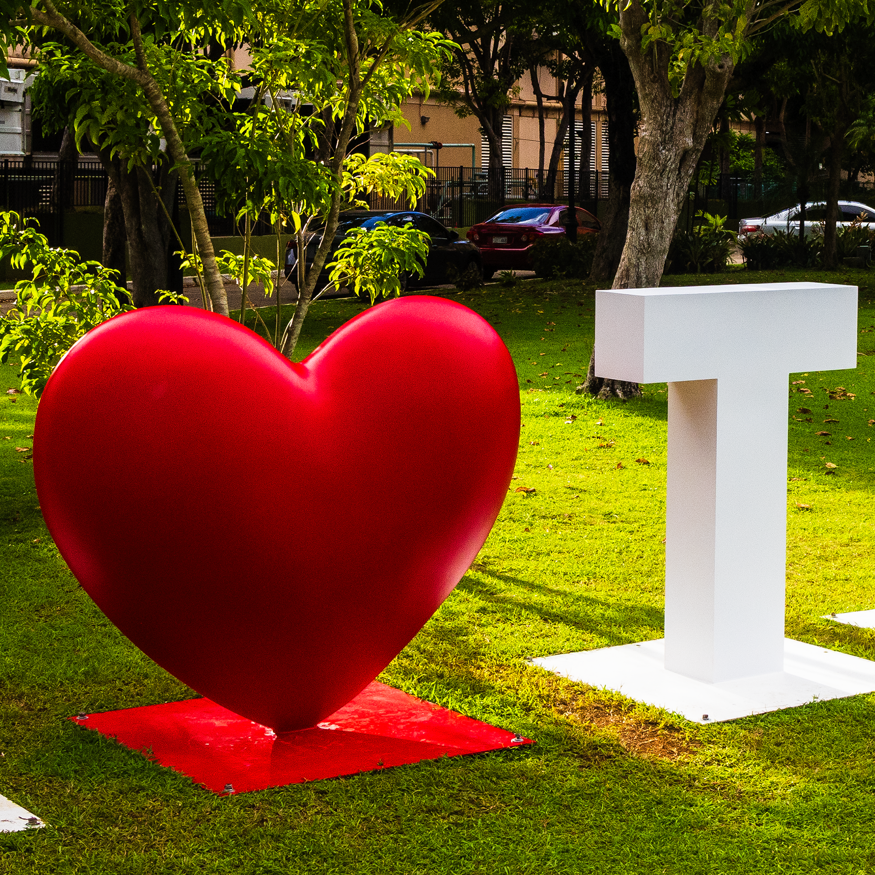 A close-up view focusing on the smooth, vibrant red heart sculpture of the I Love Tumon landmark sign in Guam.