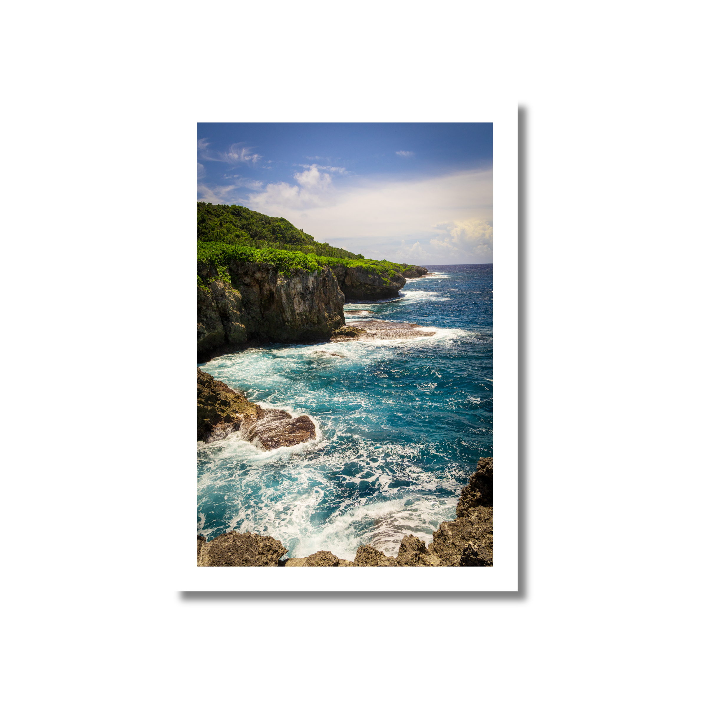 A high-angle view of rugged, porous limestone cliffs and a natural stone arch on the eastern coast of Guam, with blue Pacific Ocean waves crashing against the rocks.