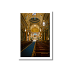 Symmetrical wide-angle photograph capturing the golden lighting and ornate Renaissance Revival architecture inside St. Jean Baptiste Church in NYC.