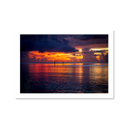 Fine art landscape photo of a sunset over Tumon Bay, Guam, with silhouettes of paddleboarders on the Philippine Sea.